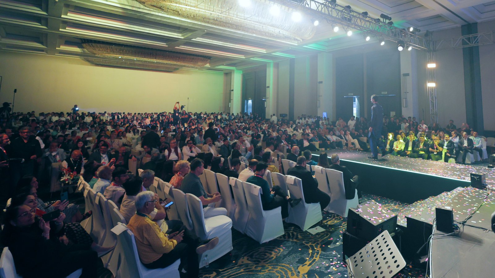 GLOBOIL India 2025 Awards Night — packed Grand Ballroom audience watching the on-stage presentation, confetti on the runway
