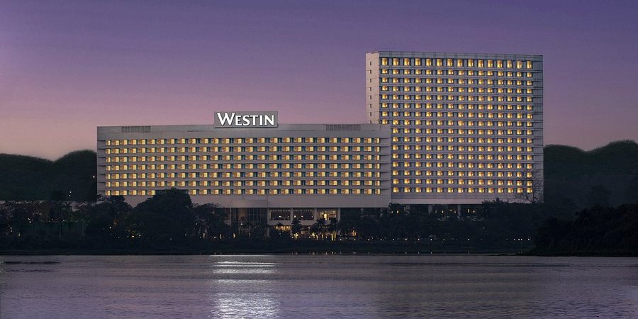 The Westin Mumbai Powai Lake at twilight — the iconic illuminated facade reflected on Powai Lake